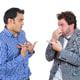 man pointing at another man while holding nose to blame him for bad breath